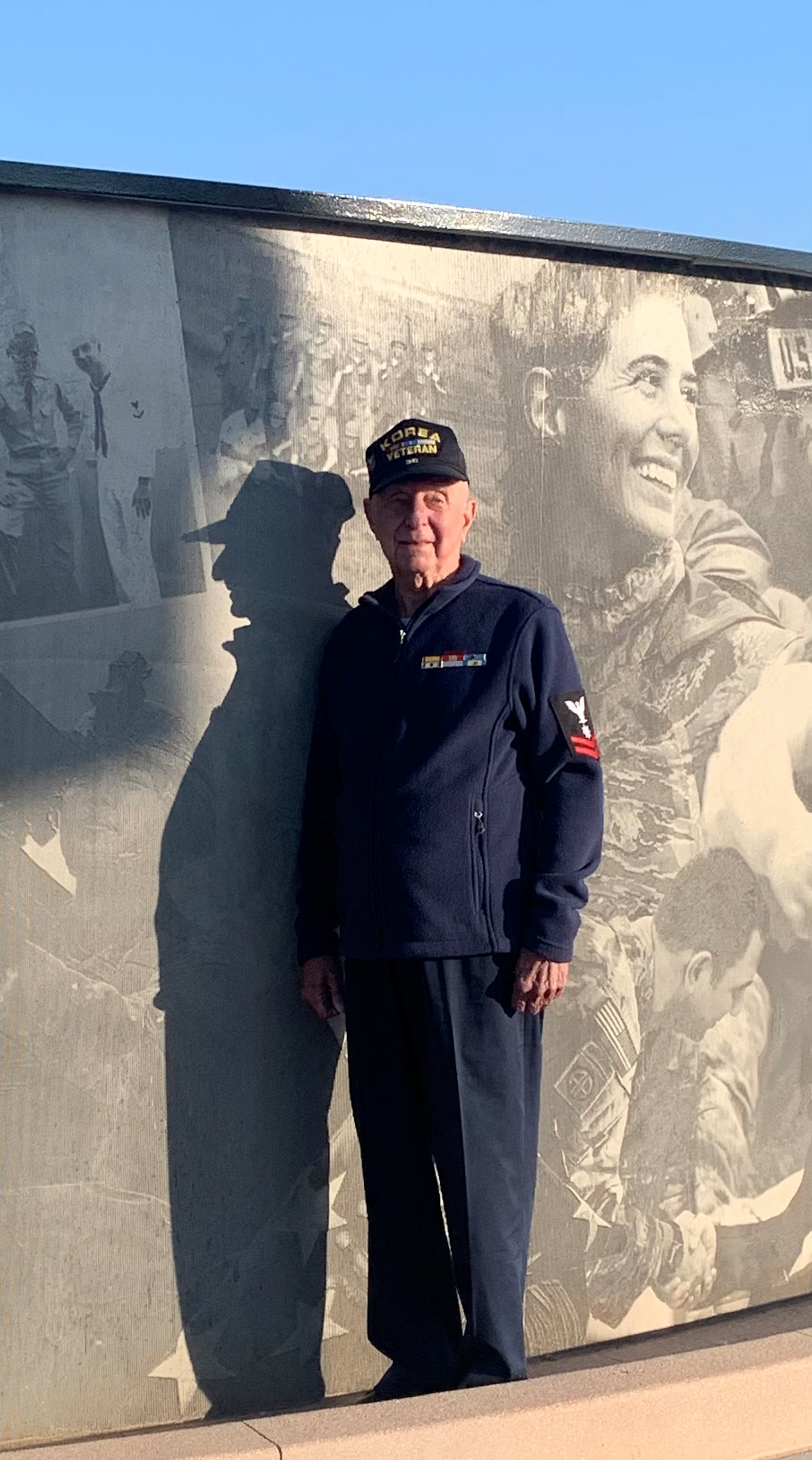 Emerson G. Dickson stands proudly next to the photo of him and his brother at the Adams County Veteran’s Memorial Story Wall. 